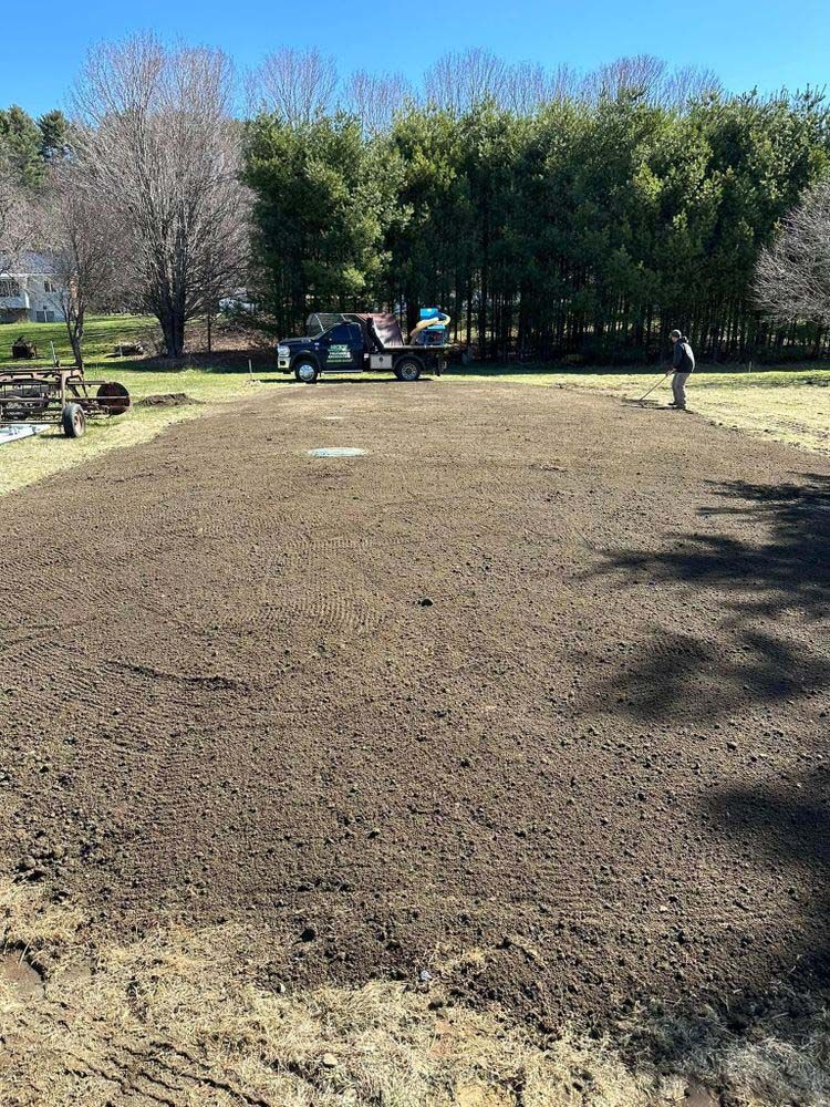 A man is standing in the middle of a dirt field.