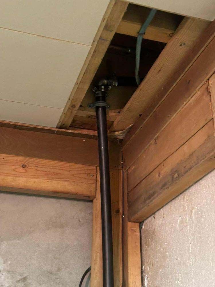 A pipe is coming out of the ceiling of a wooden building.