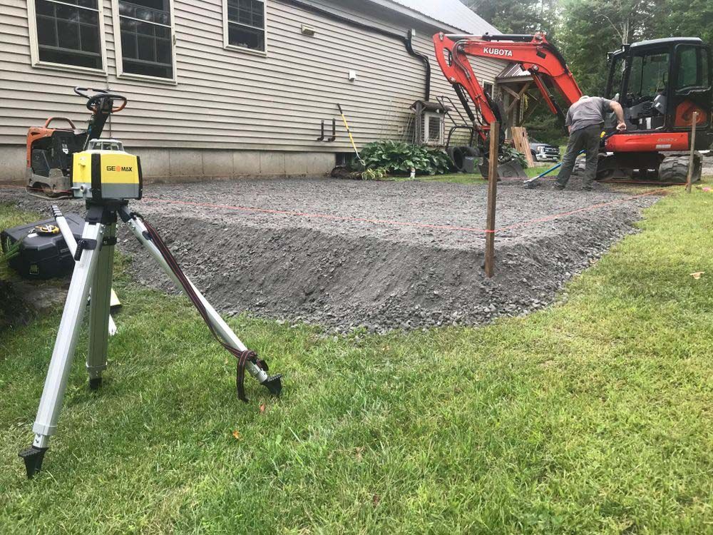 A tripod is sitting in the grass in front of a house.
