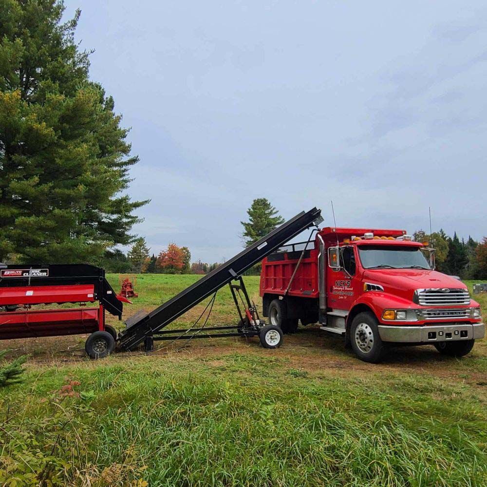 A red truck with a conveyor belt attached to it