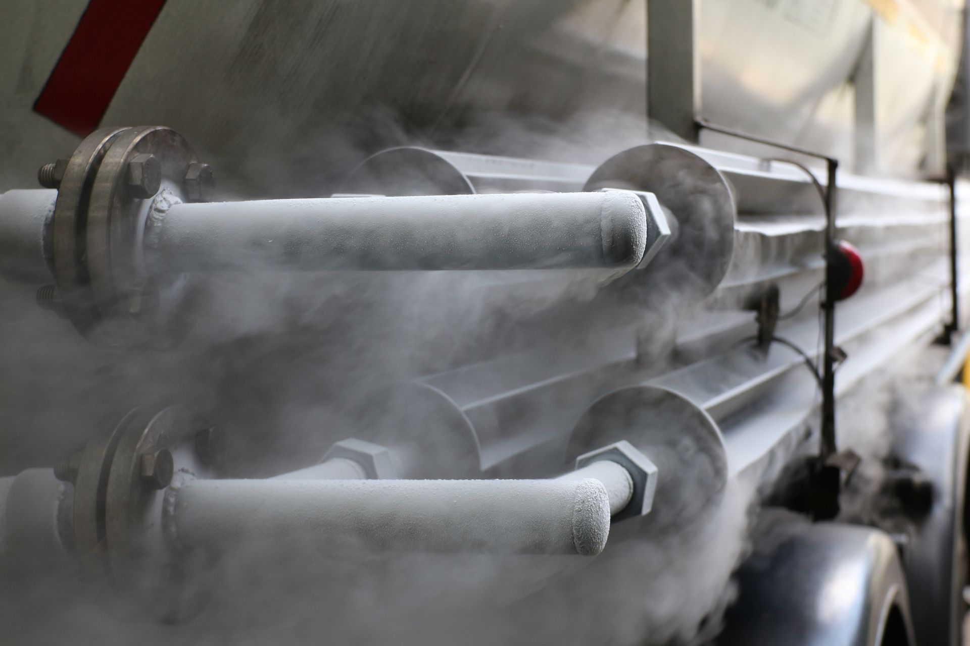 A close up of a truck with smoke coming out of the pipes.