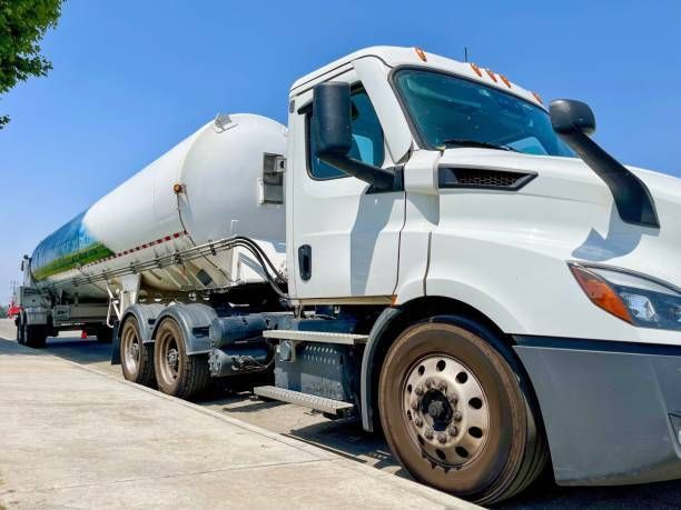 A white semi truck is parked on the side of the road.