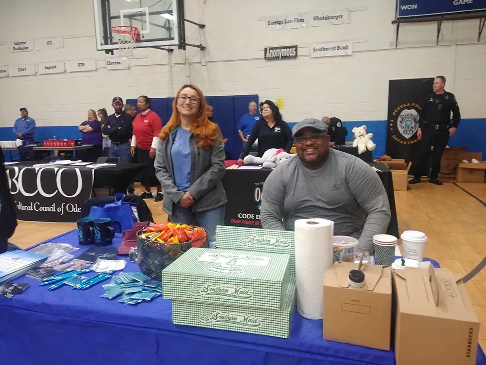 A man and a woman are sitting at a table in a gym. A man and a woman are sitting at a table in a gym.