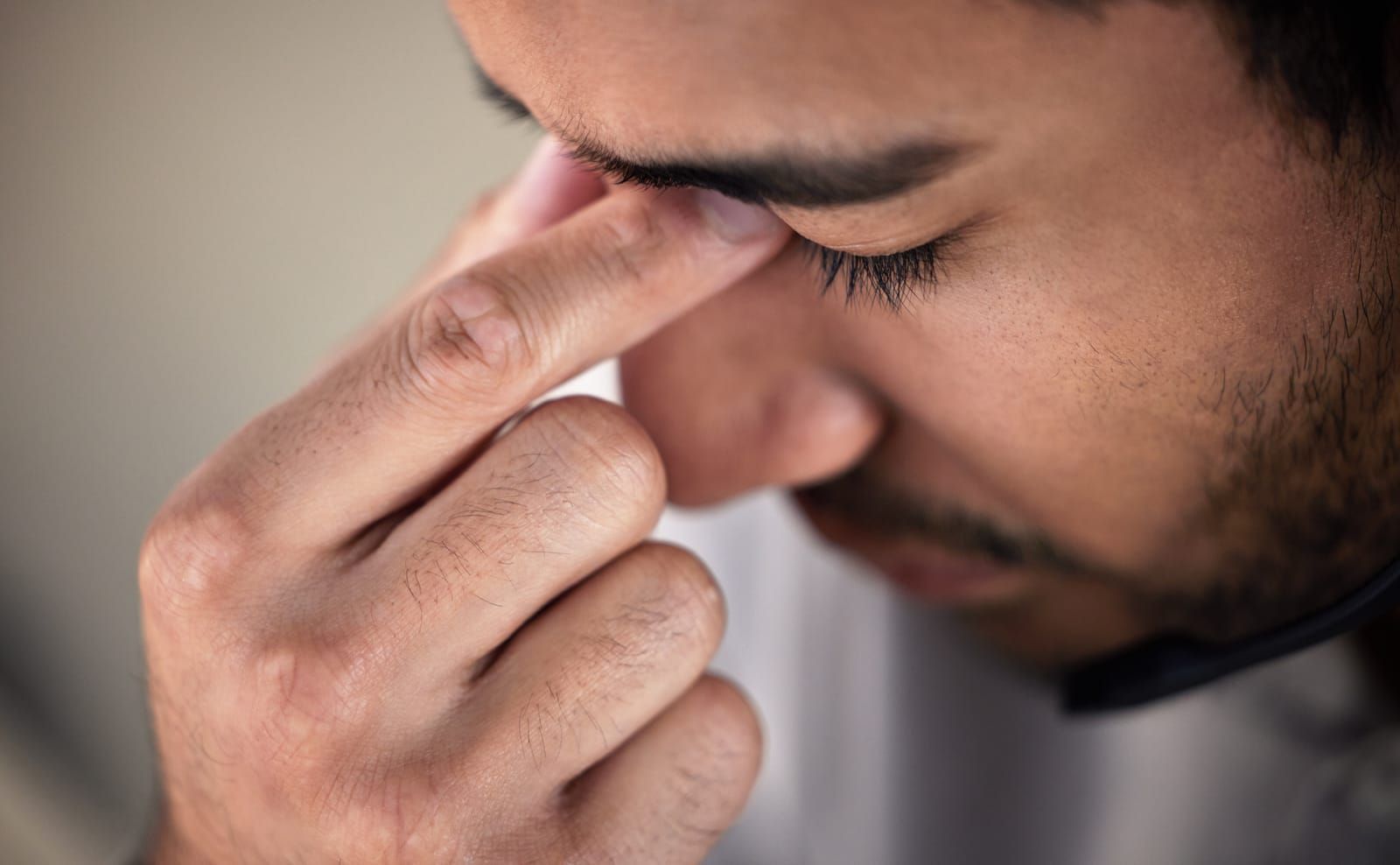 man holding his nose bridge due to facial pain pressure