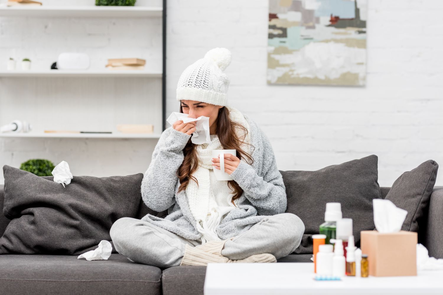 sick-young-woman-in-warm-clothes-sneezing