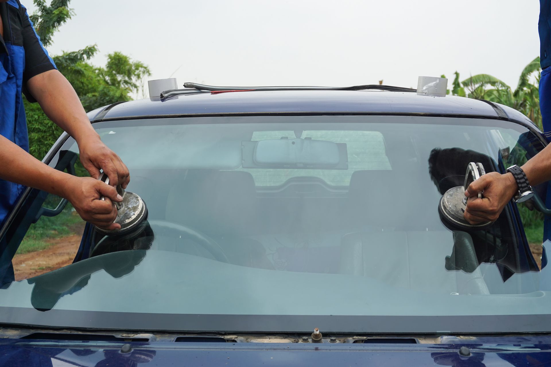 A man is installing a windshield on a car.