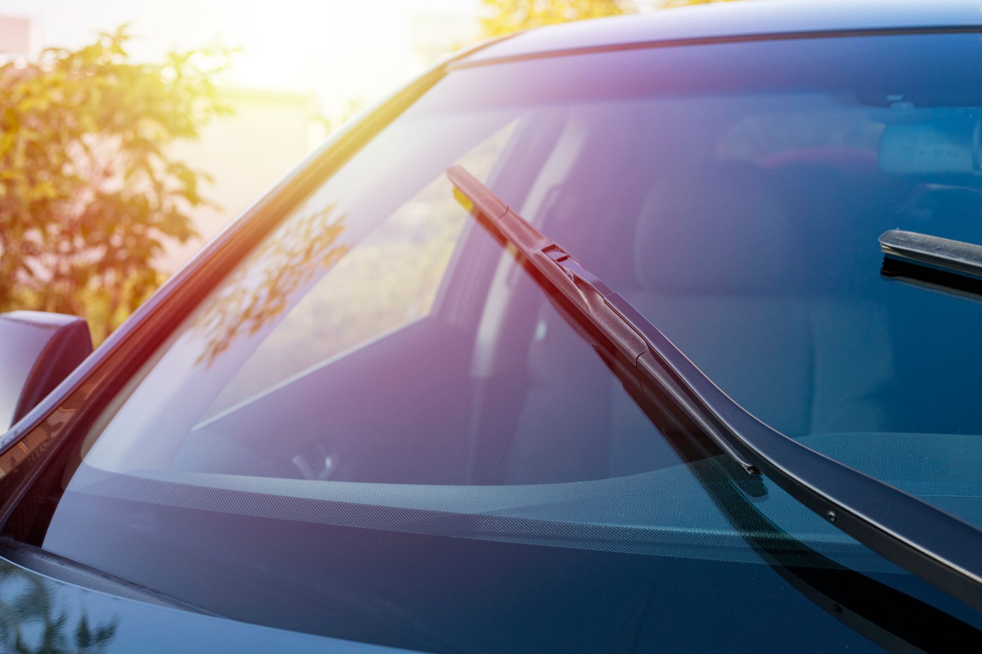 A close up of a car windshield with wiper blades on it.