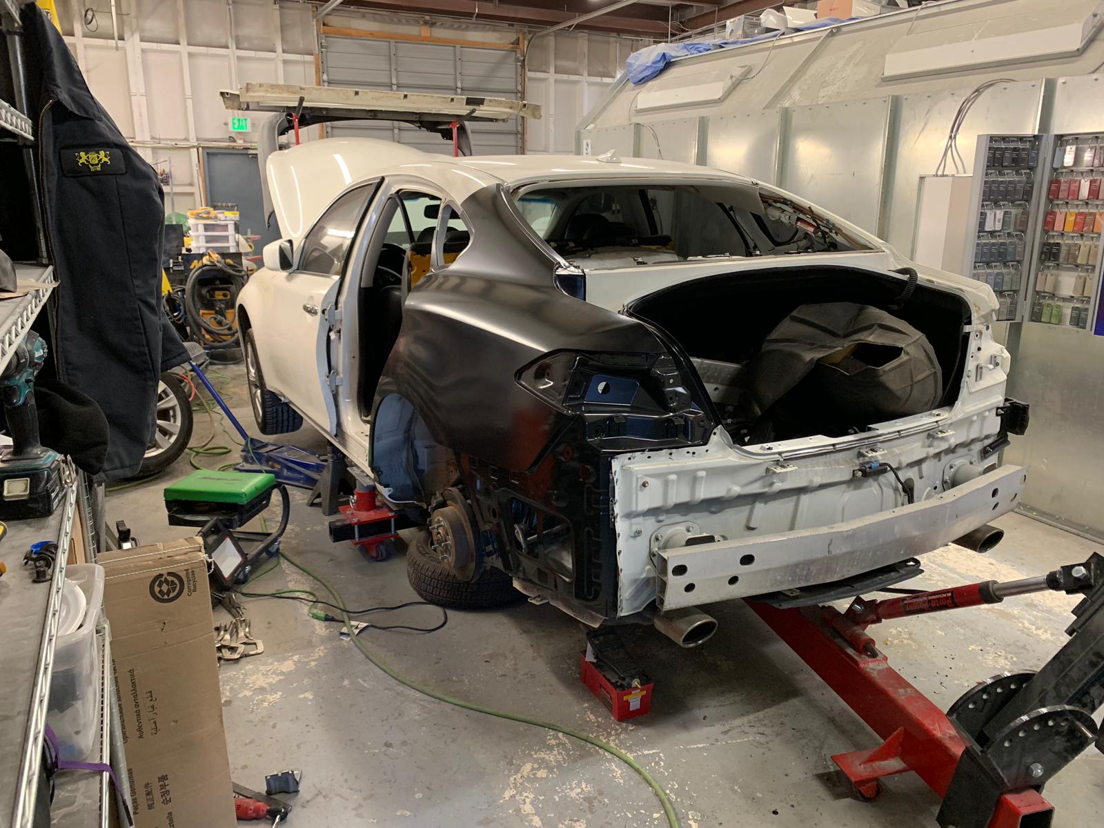 A white car is being worked on in a garage.