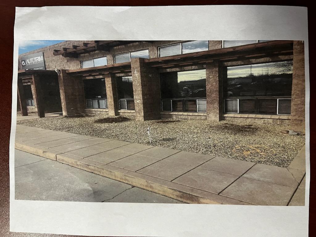 Building exterior with rectangular windows, supported by pillars, and a low gravel garden bed.