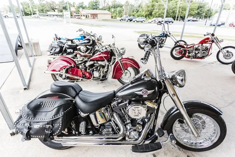 Several motorcycles parked outside, including a black Harley-Davidson with saddlebags and a red Indian-style bike.