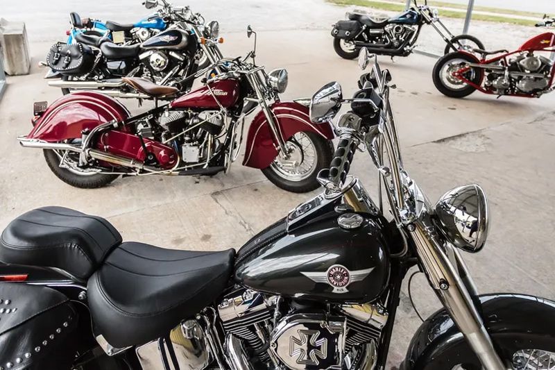 Several motorcycles parked, including a red Indian Chief and a black Harley-Davidson.
