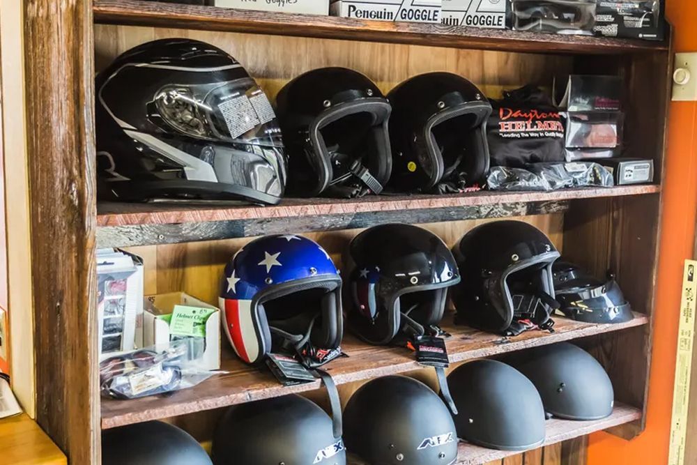 Shelves displaying black motorcycle helmets, one with a blue, white, and red star design.