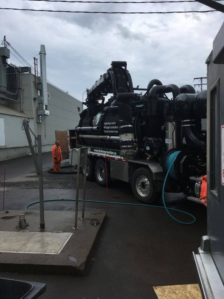 Un camion aspirateur est garé devant un bâtiment