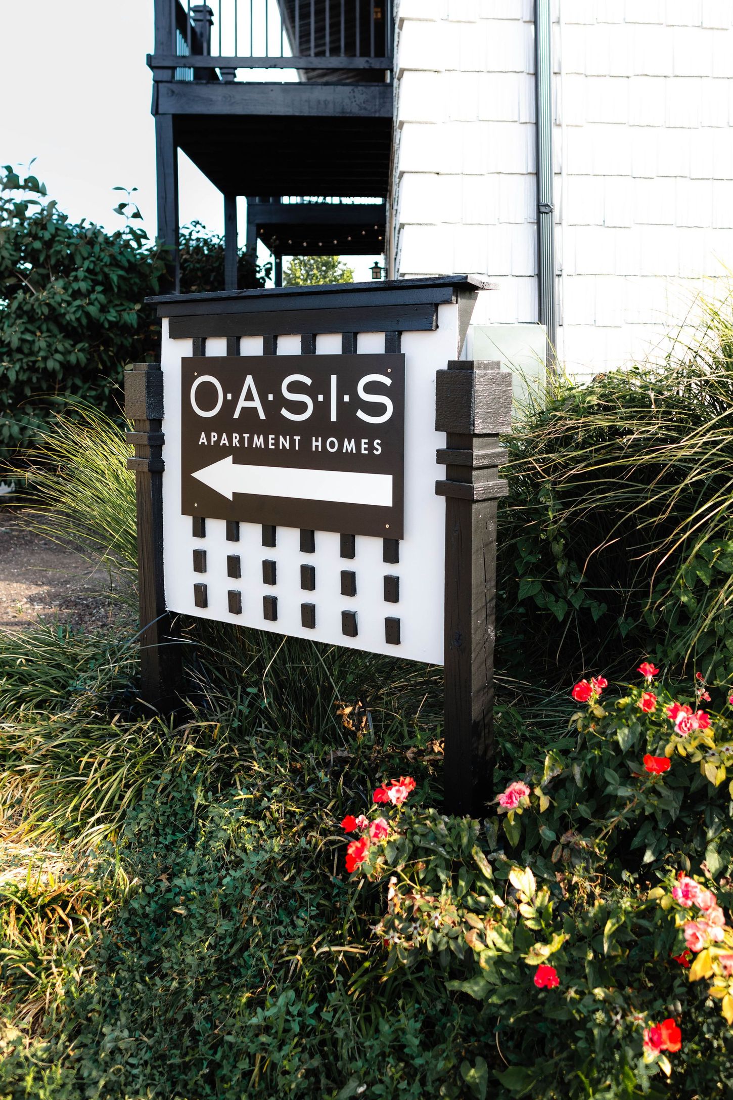 a sign for oasis apartment homes with an arrow pointing to the right