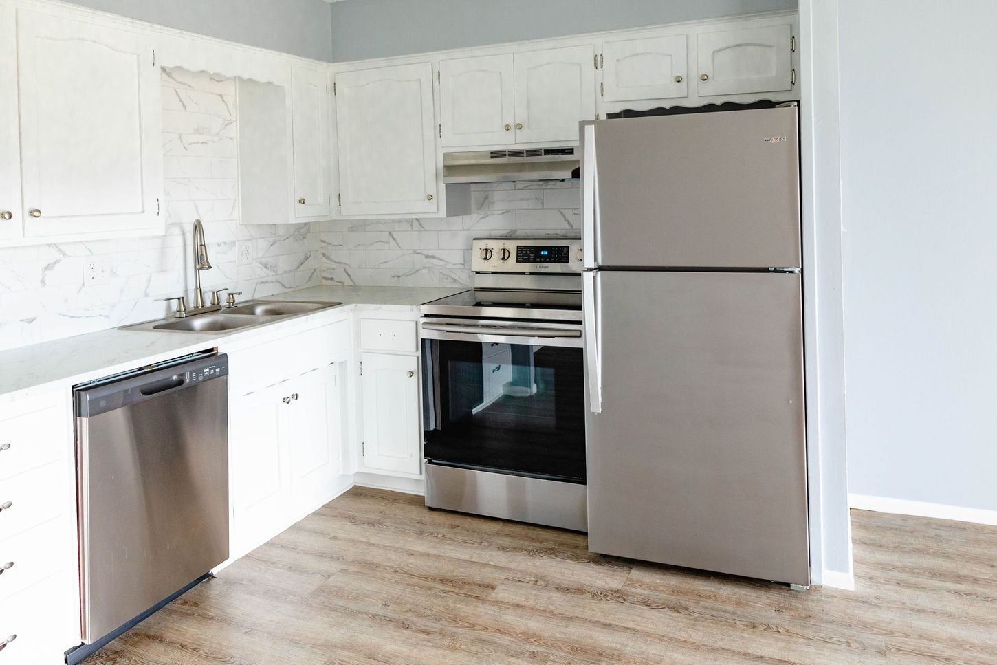 a kitchen with stainless steel appliances and a ge refrigerator