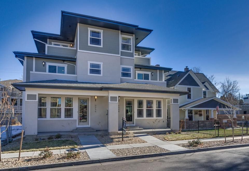 A large house with a lot of windows and a blue sky in the background.