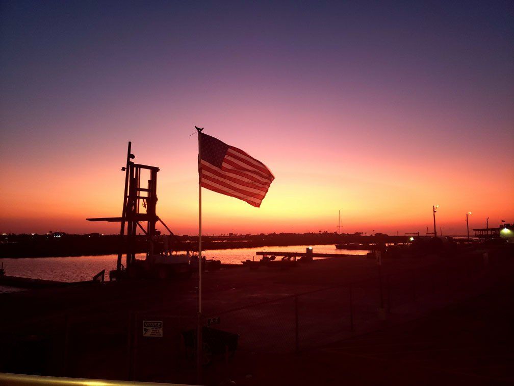 A sunset with an american flag in the foreground