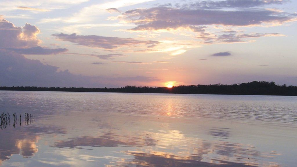 The sun is setting over a large body of water.