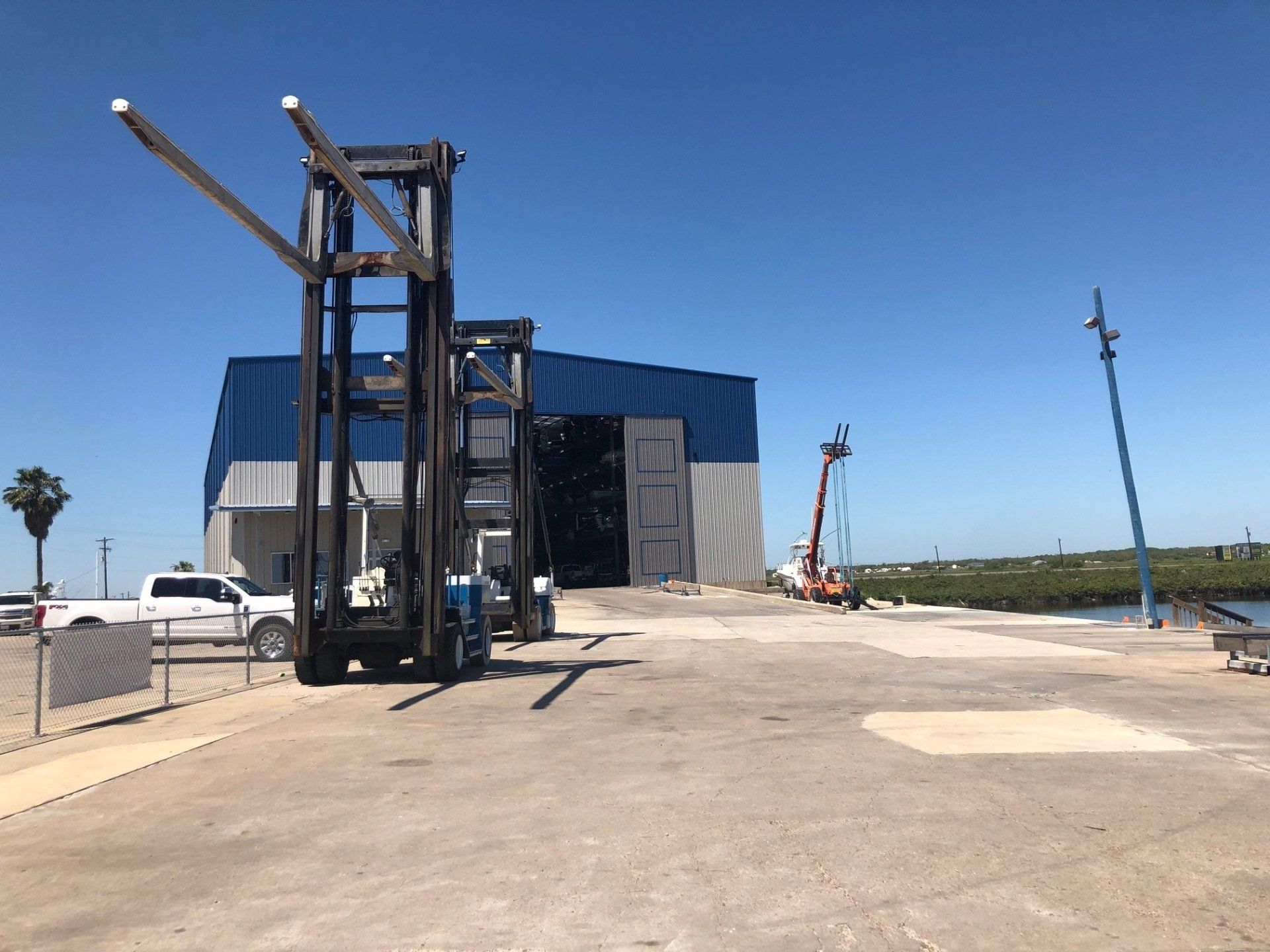 A large forklift is parked in front of a building.