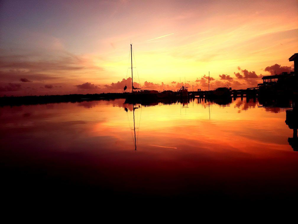A sunset over a body of water with boats in the water