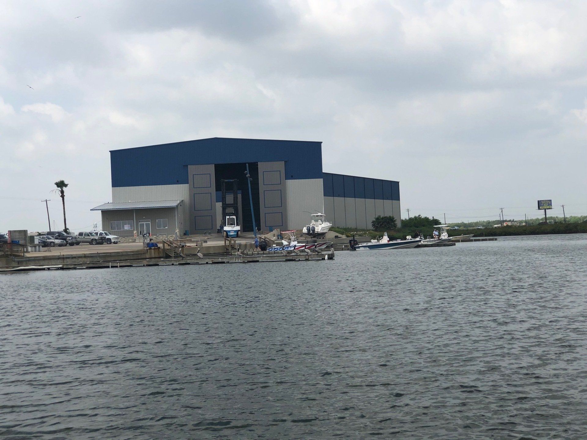 A large building sits on the shore of a body of water.