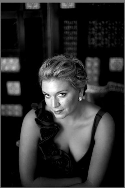 Woman in formal attire, looking up, black and white photo.