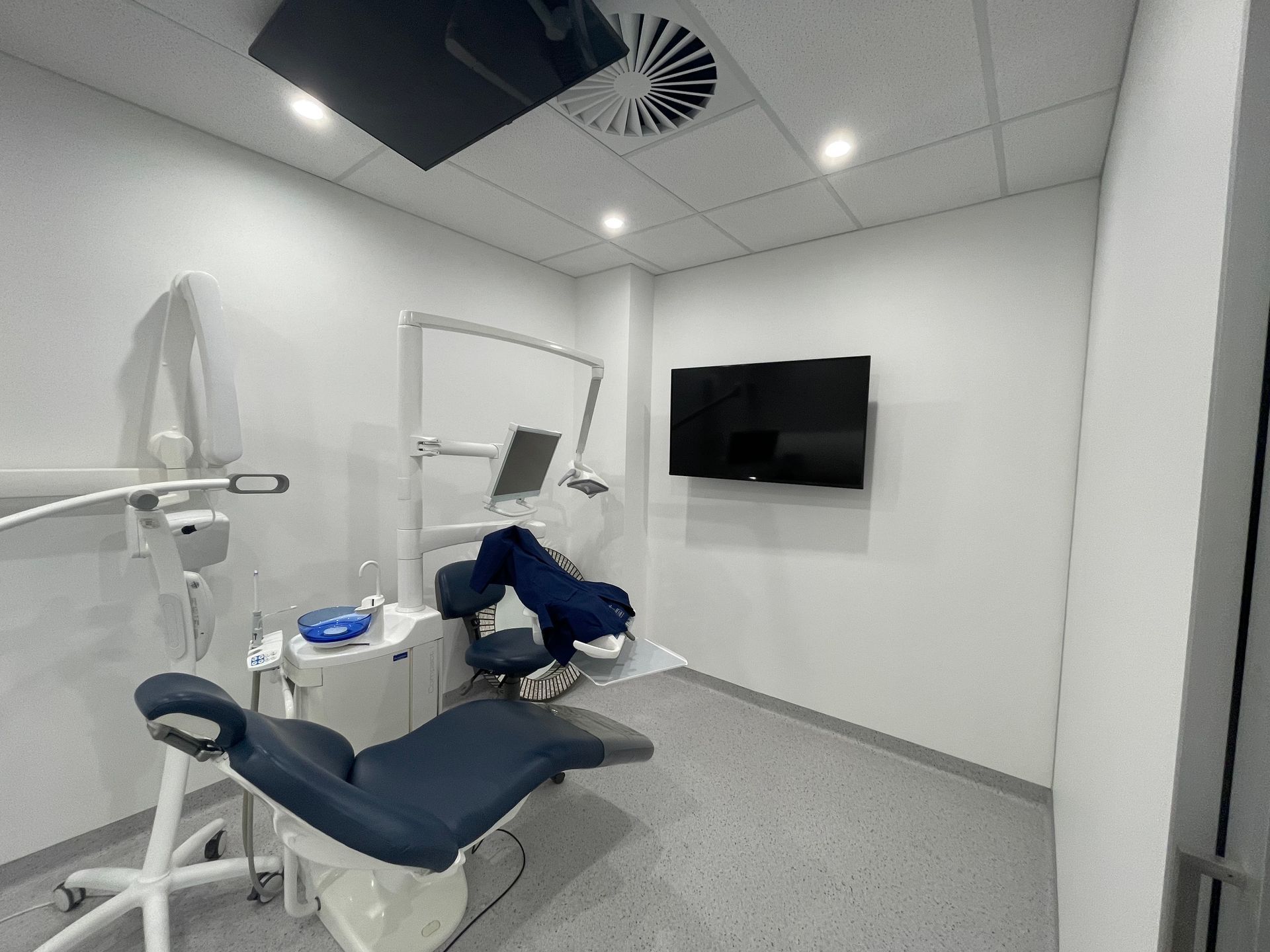 A Modern Dental Examination Room With a Blue Patient Chair — Gray Projects in Woodford, QLD