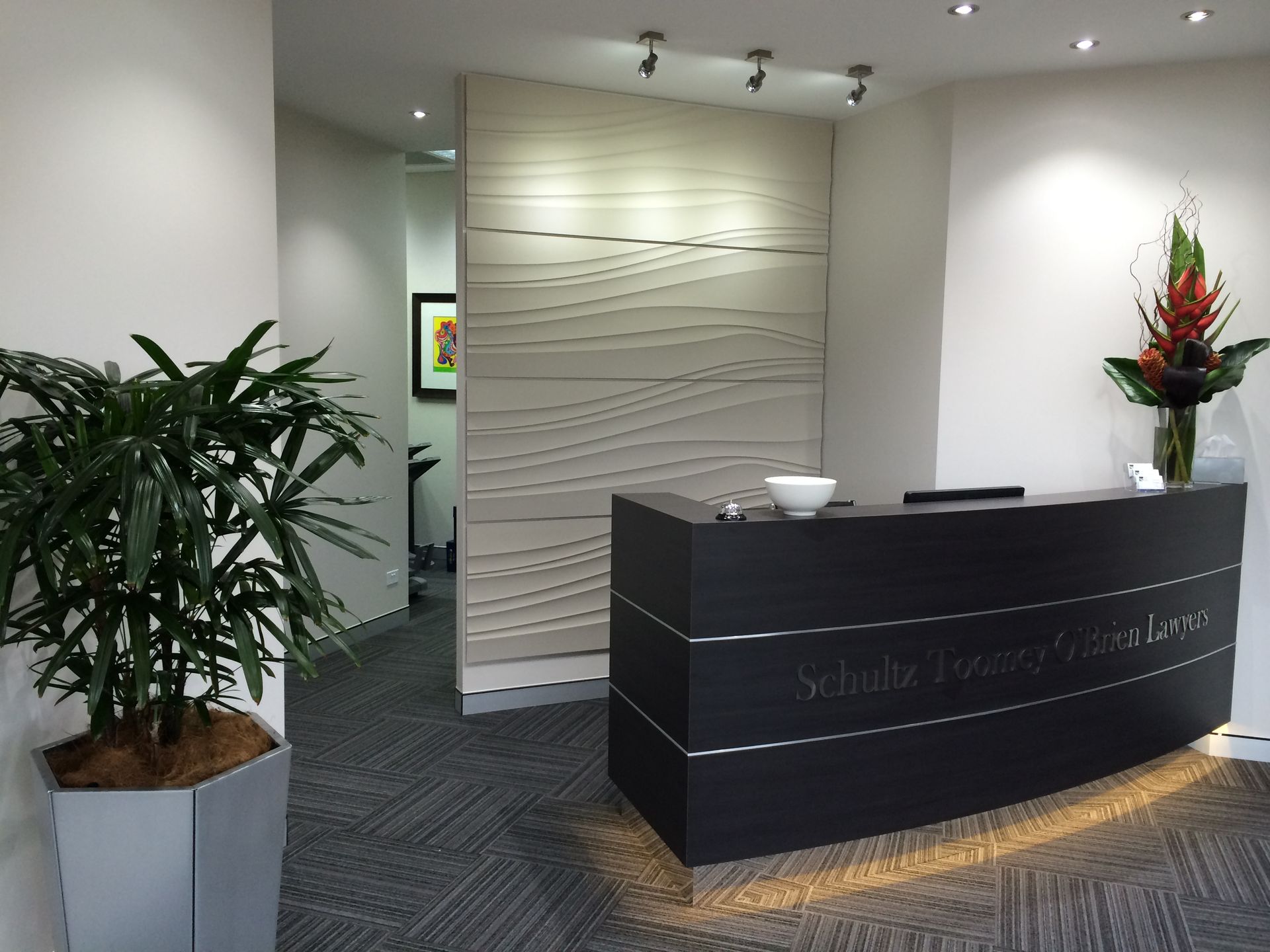 Modern Reception Area With a Dark, Curved Desk — Gray Projects in Woodford, QLD