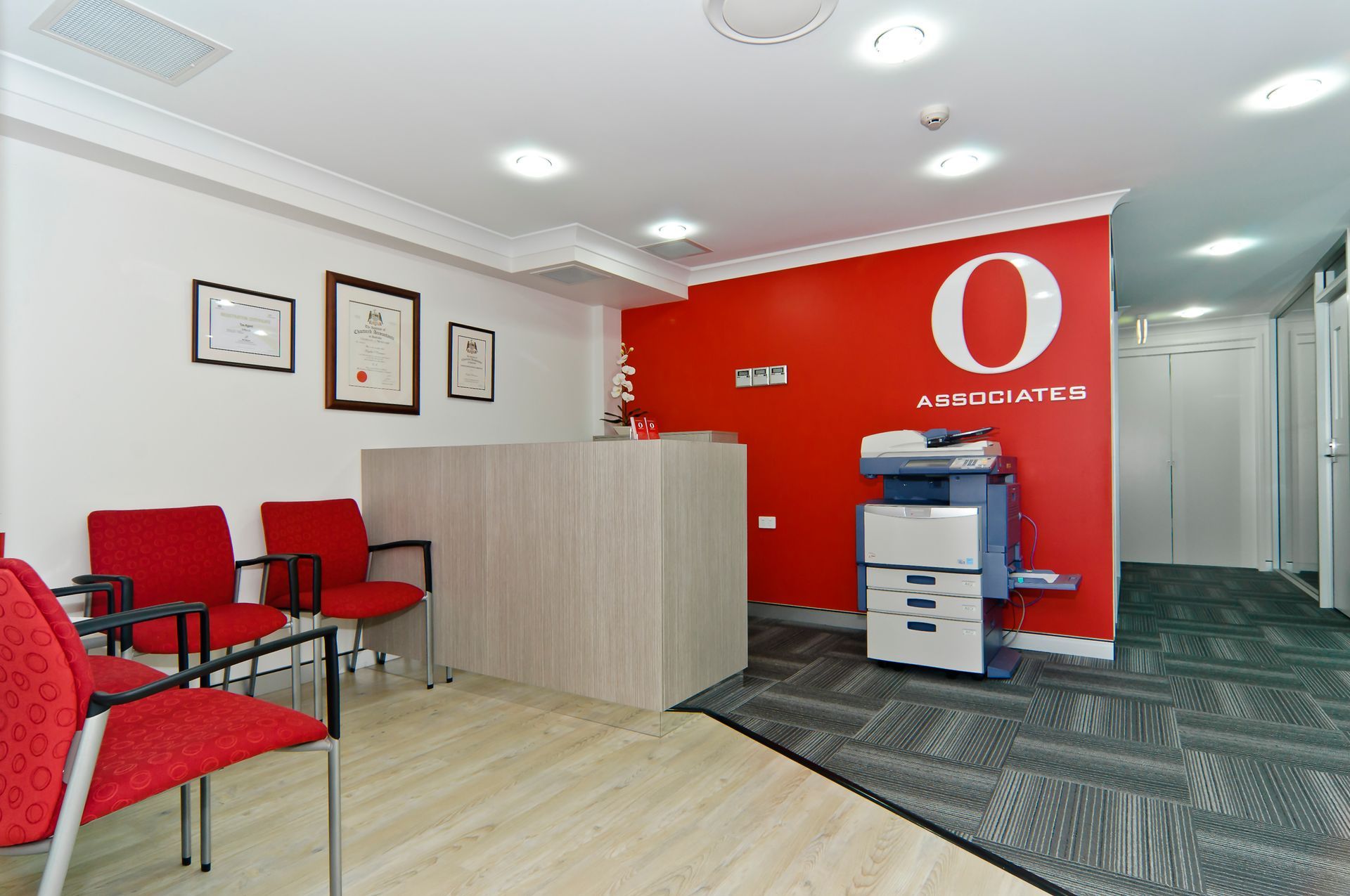 Reception Area With Red Chairs, Light-wood Desk — Gray Projects in Woodford, QLD