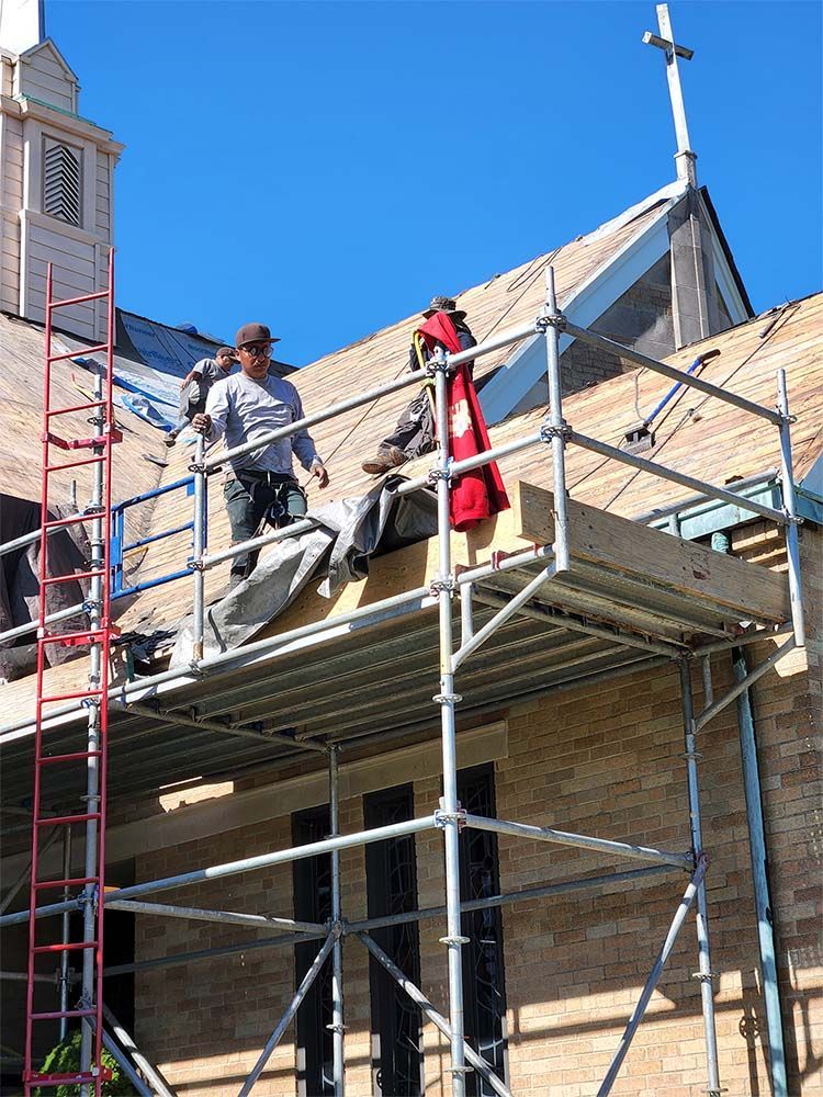 Woman in straw hat smiles, holding wine glass near a lake.