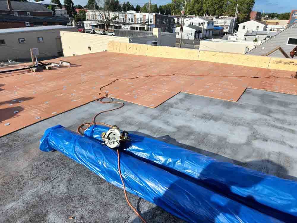 Woman in straw hat smiles, holding wine glass near a lake.