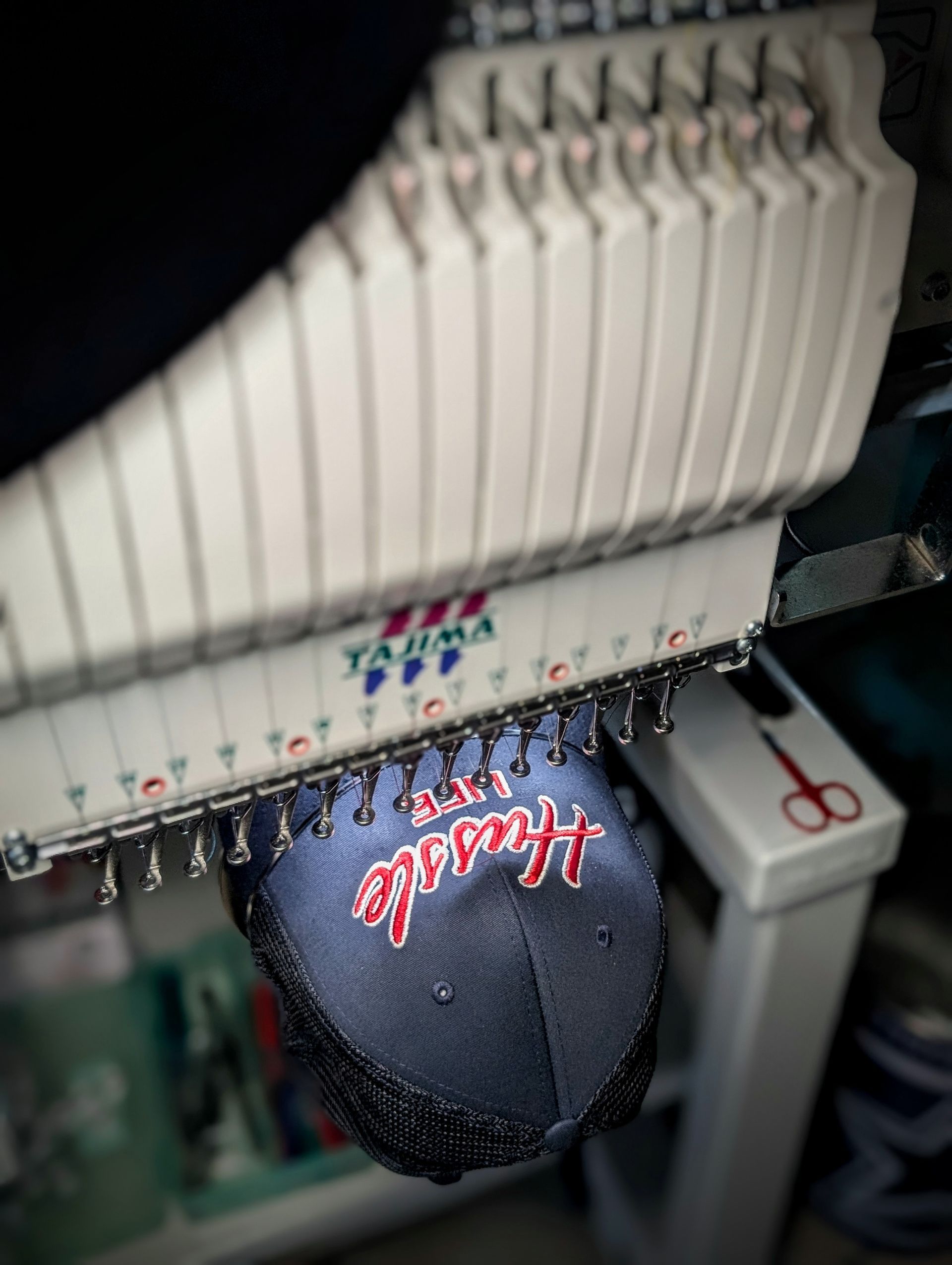 A close up of a hat being embroidered on a machine.
