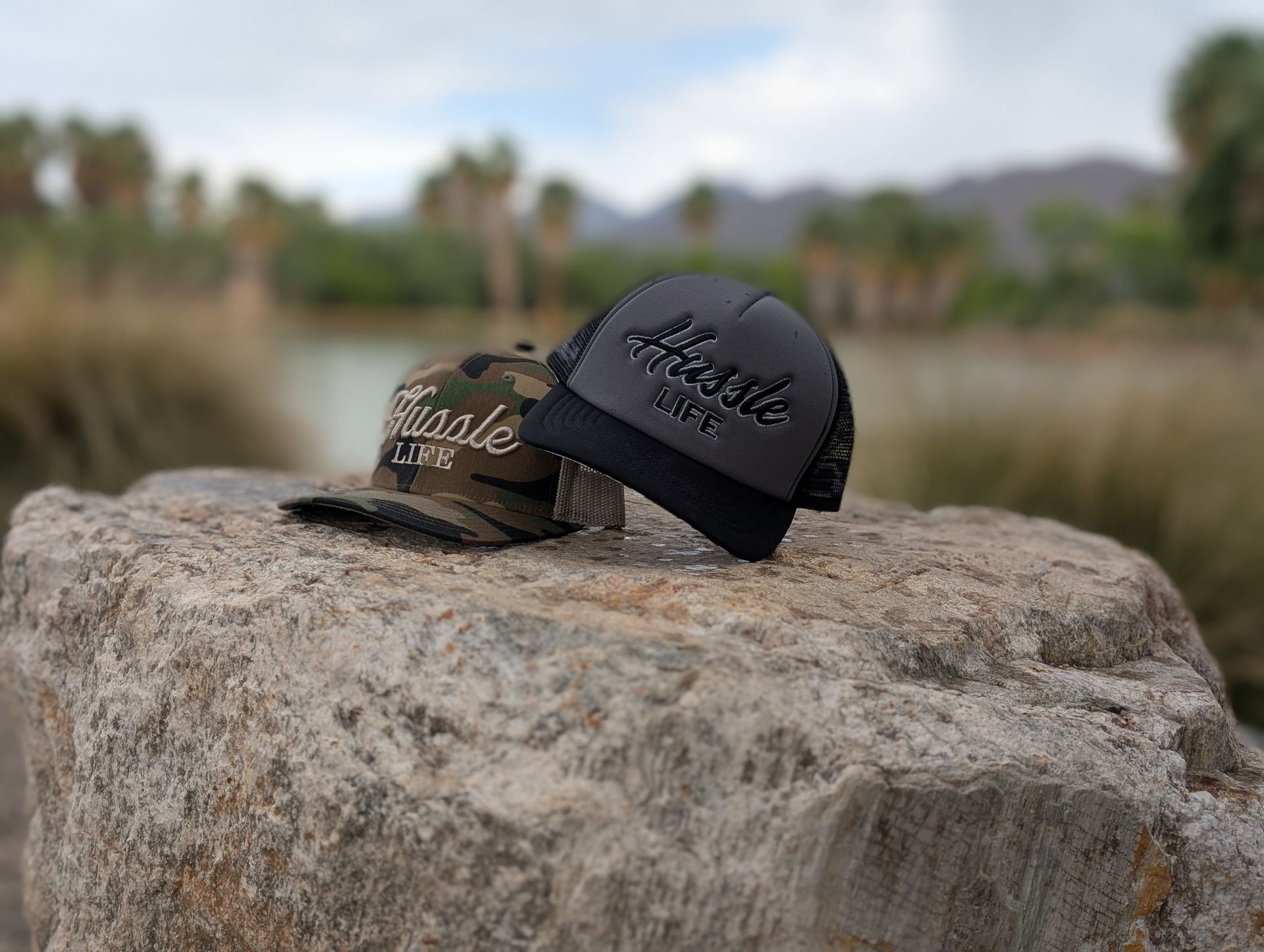 Two hats are sitting on top of a large rock.