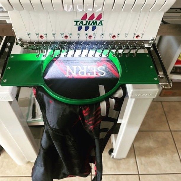 A tajima embroidery machine is sitting on a tiled floor