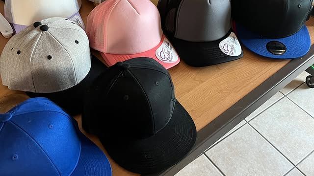 A bunch of hats are sitting on a wooden table.