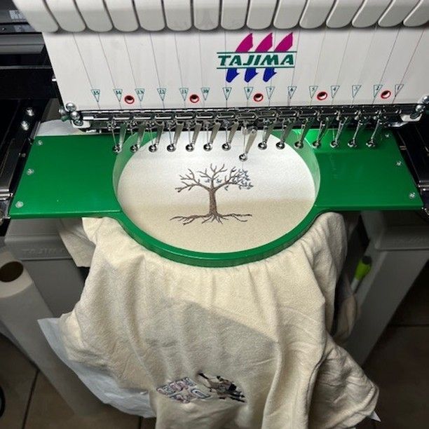 A tajima machine with a tree embroidered on it