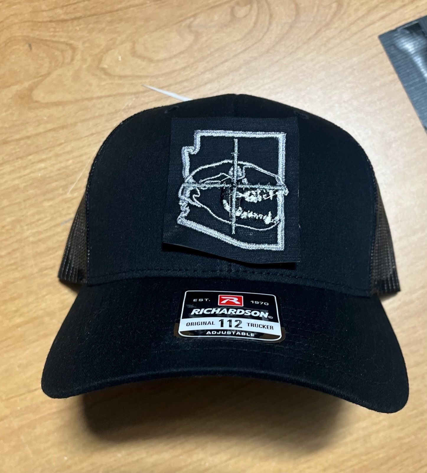 Black trucker hat with Arizona outline and animal skull patch; Richardson 112 label.