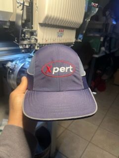 A person wearing a hat that says embroidery & co. on it