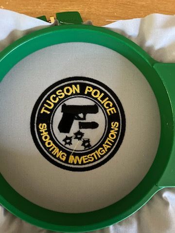 Tucson Police Shooting Investigations patch embroidered in a green hoop, black text and emblem on white fabric.