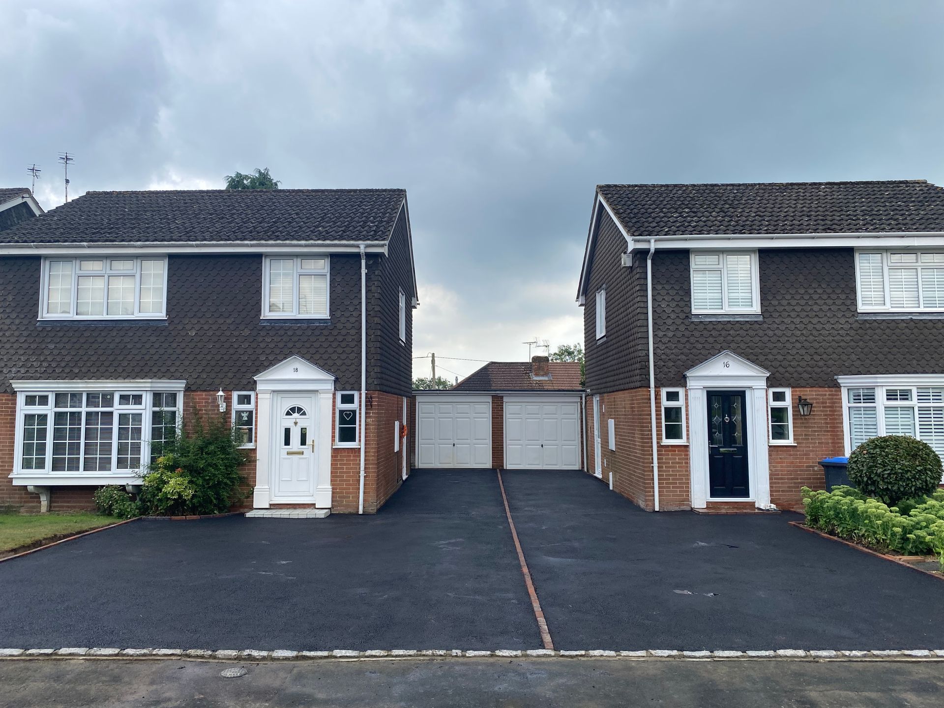 Two houses are next to each other on a cloudy day
