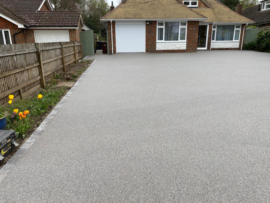 grey resin bound driveway leading to a bungalow