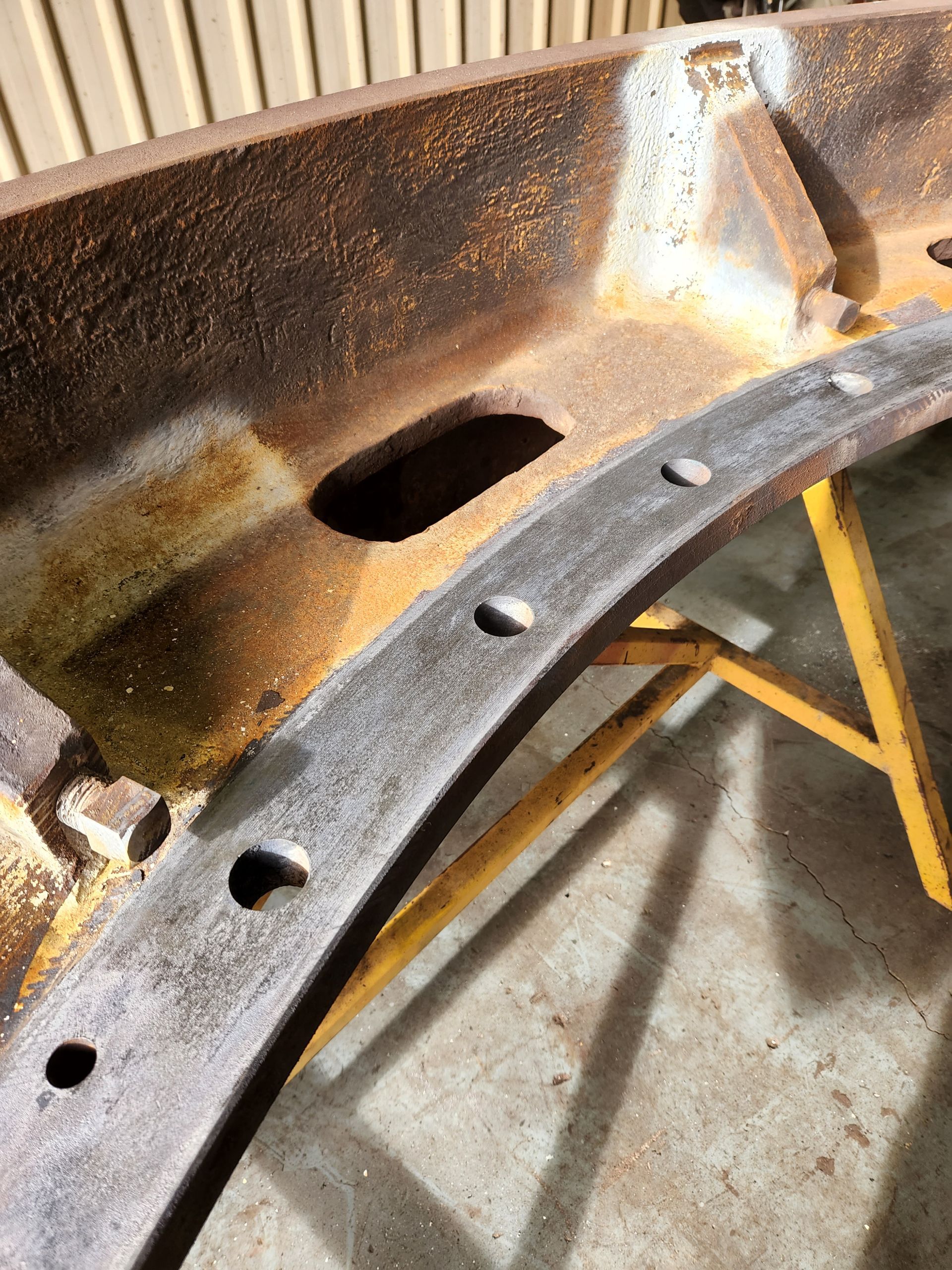 A piece of rusty metal is sitting on top of a yellow table.