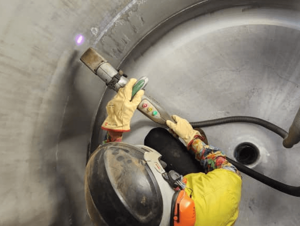 A man is wearing a helmet and gloves while using a machine.