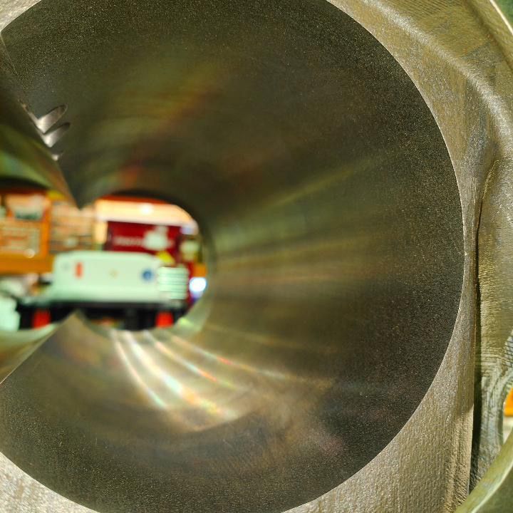 The inside of a metal pipe with a truck in the background