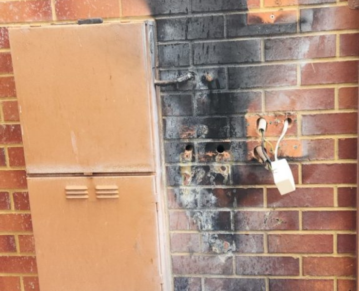 A brick wall with a brown cabinet on it