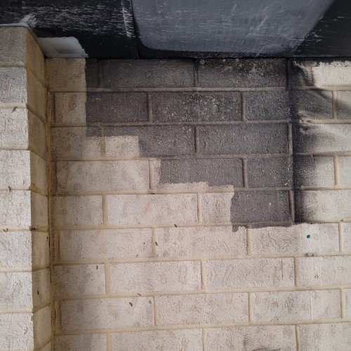 A brick wall with a gray stain on it