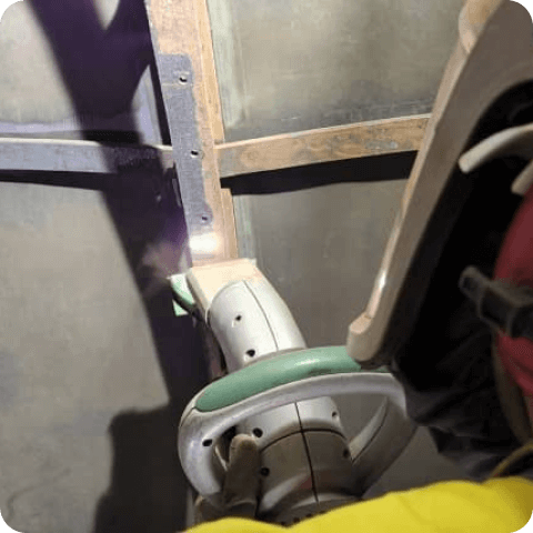 A person is using a machine to cut a piece of metal