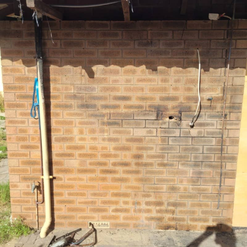 A brick wall with a pipe coming out of it