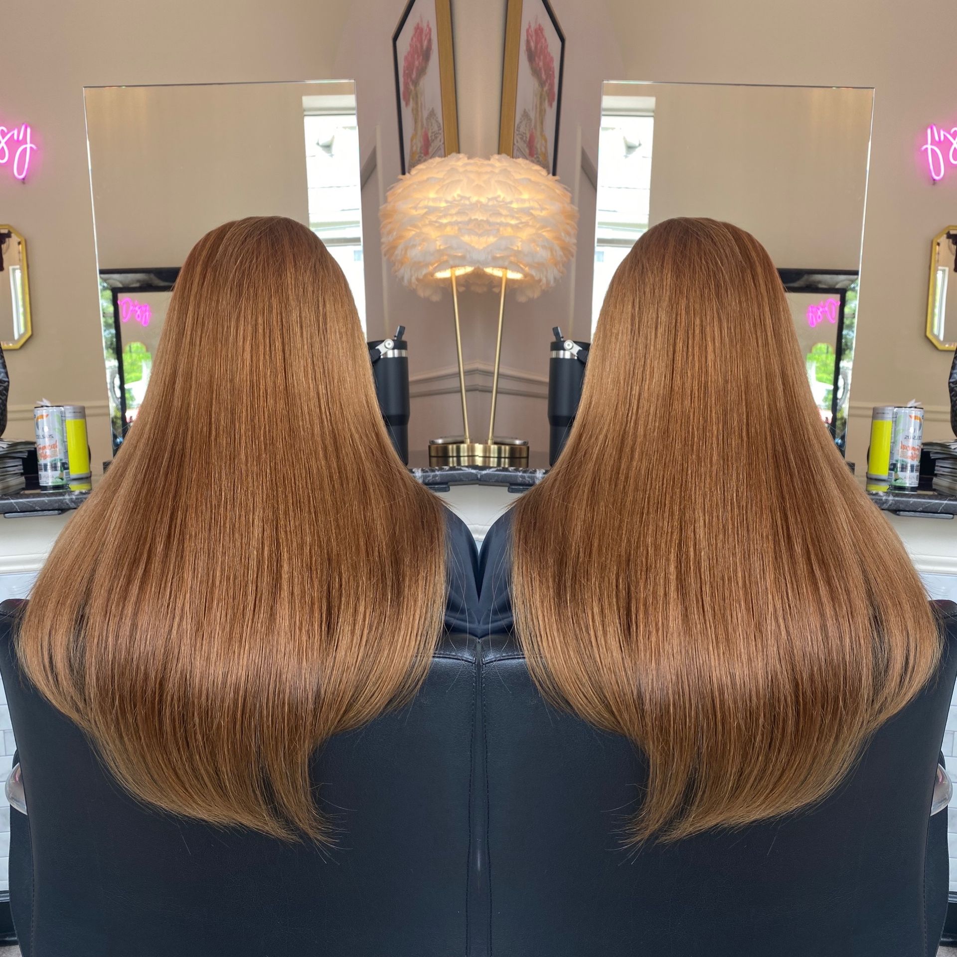 A woman with long brown hair is sitting in a chair in front of a mirror.