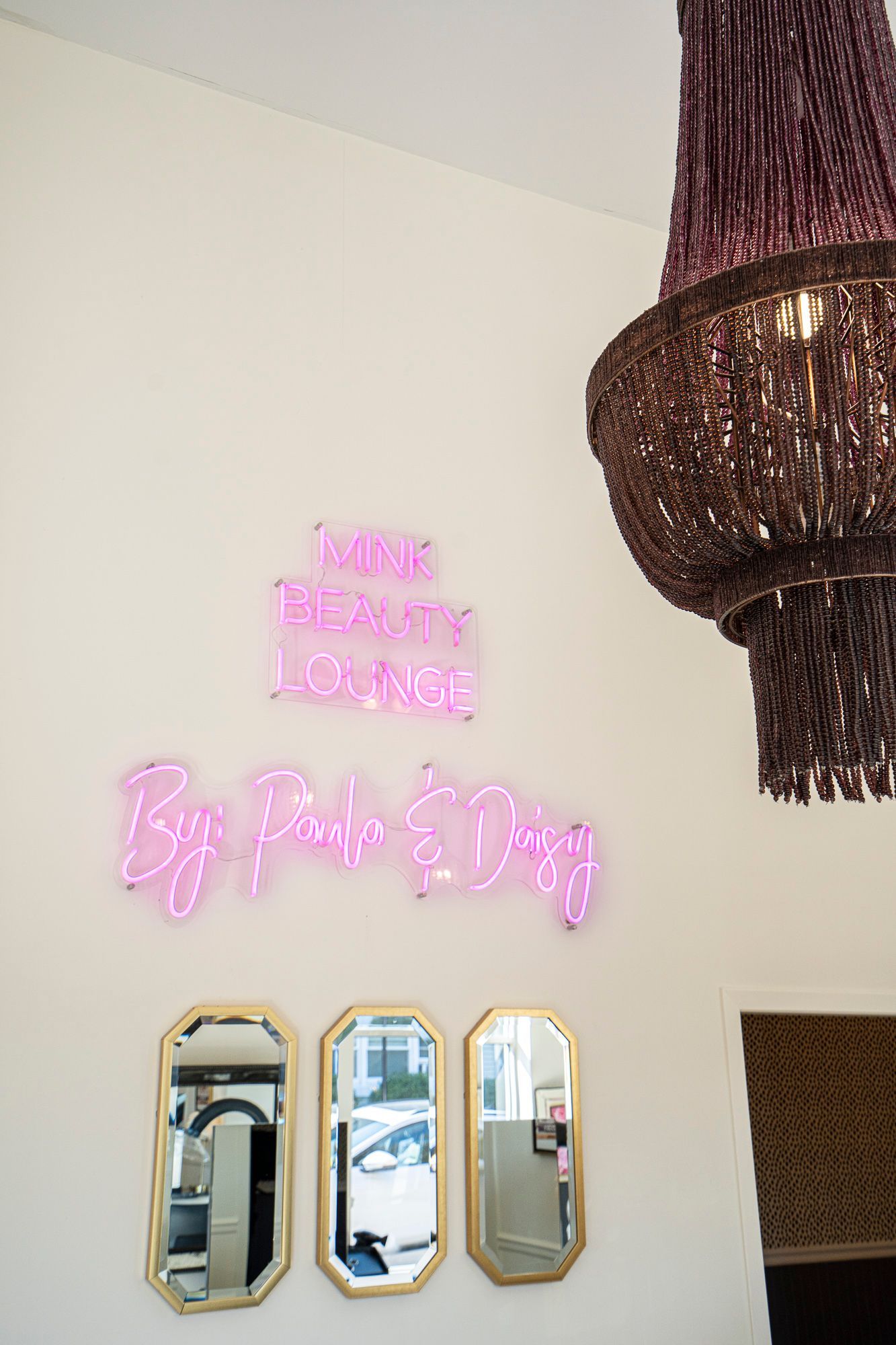 There is a neon sign on the wall above the mirrors.